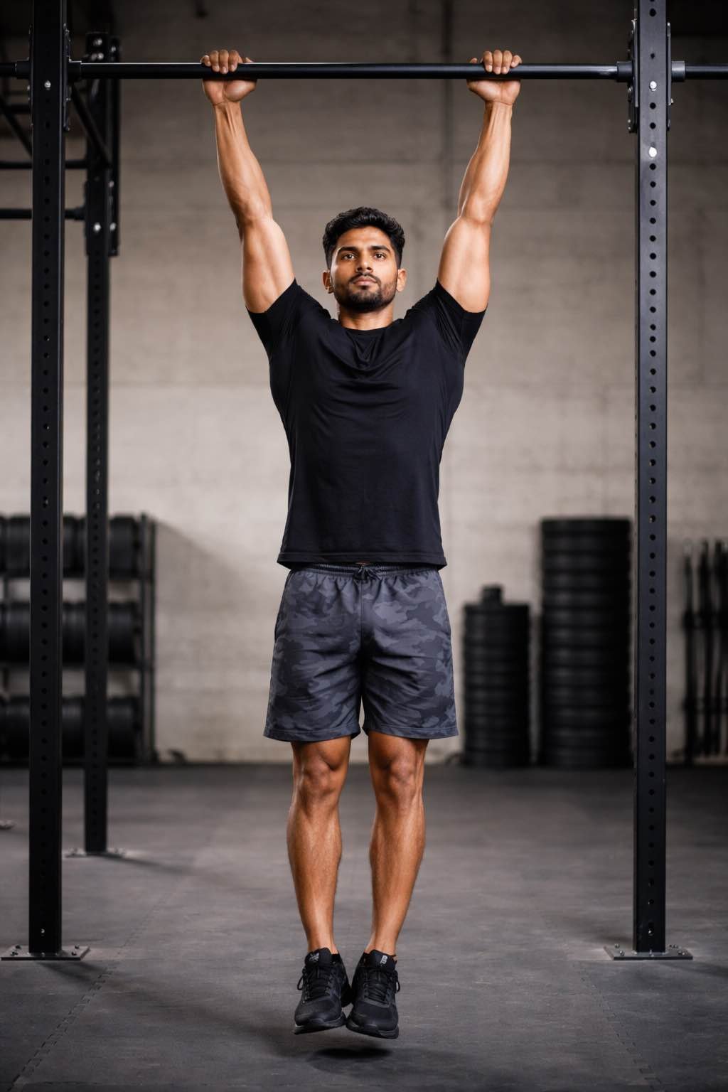 Indian man performing dead hang on pull-up bar for spinal decompression and grip strength